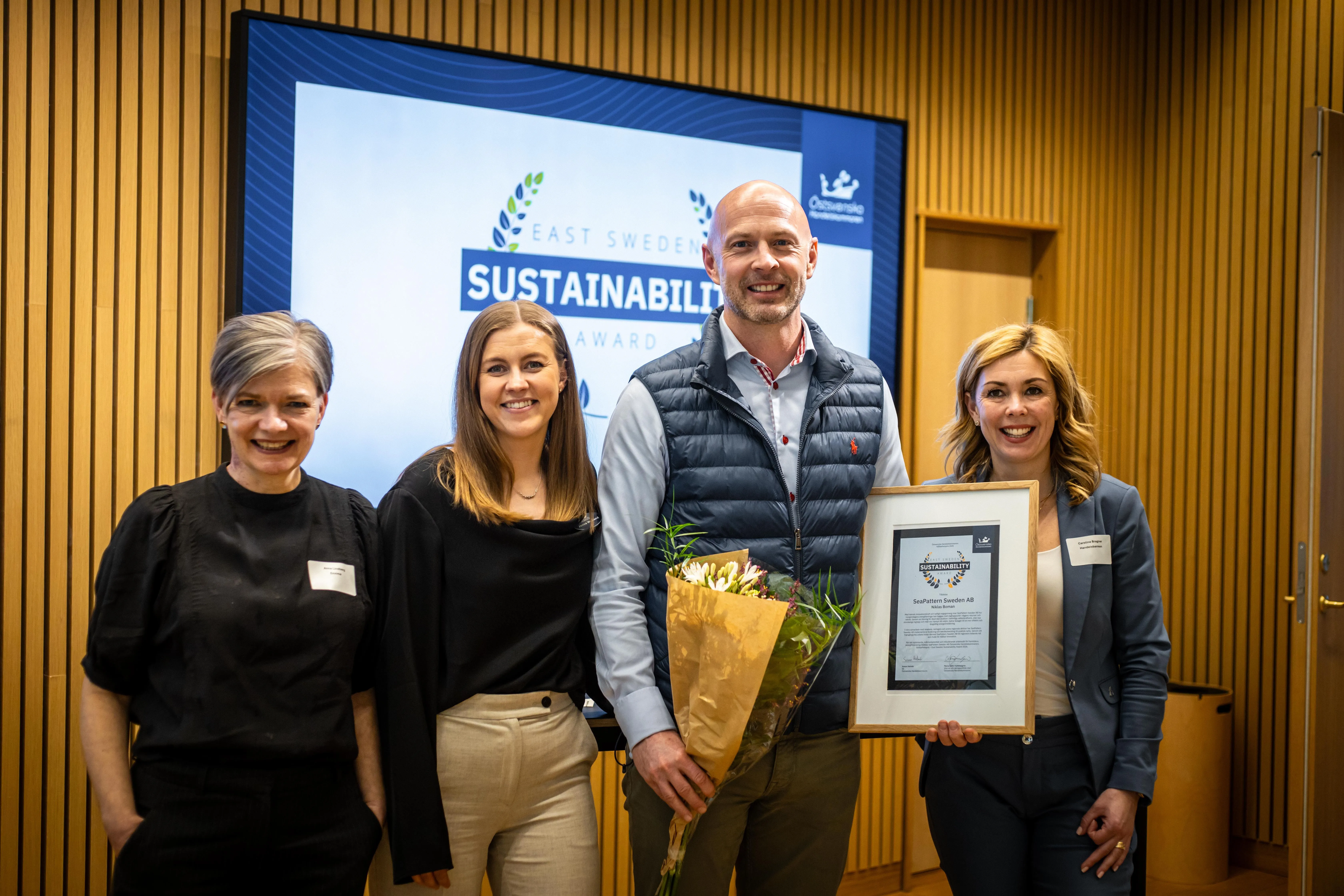 Gruppenfoto von der Verleihung des East Sweden Sustainability Award 2026 mit Blumen und einer gerahmten Urkunde.