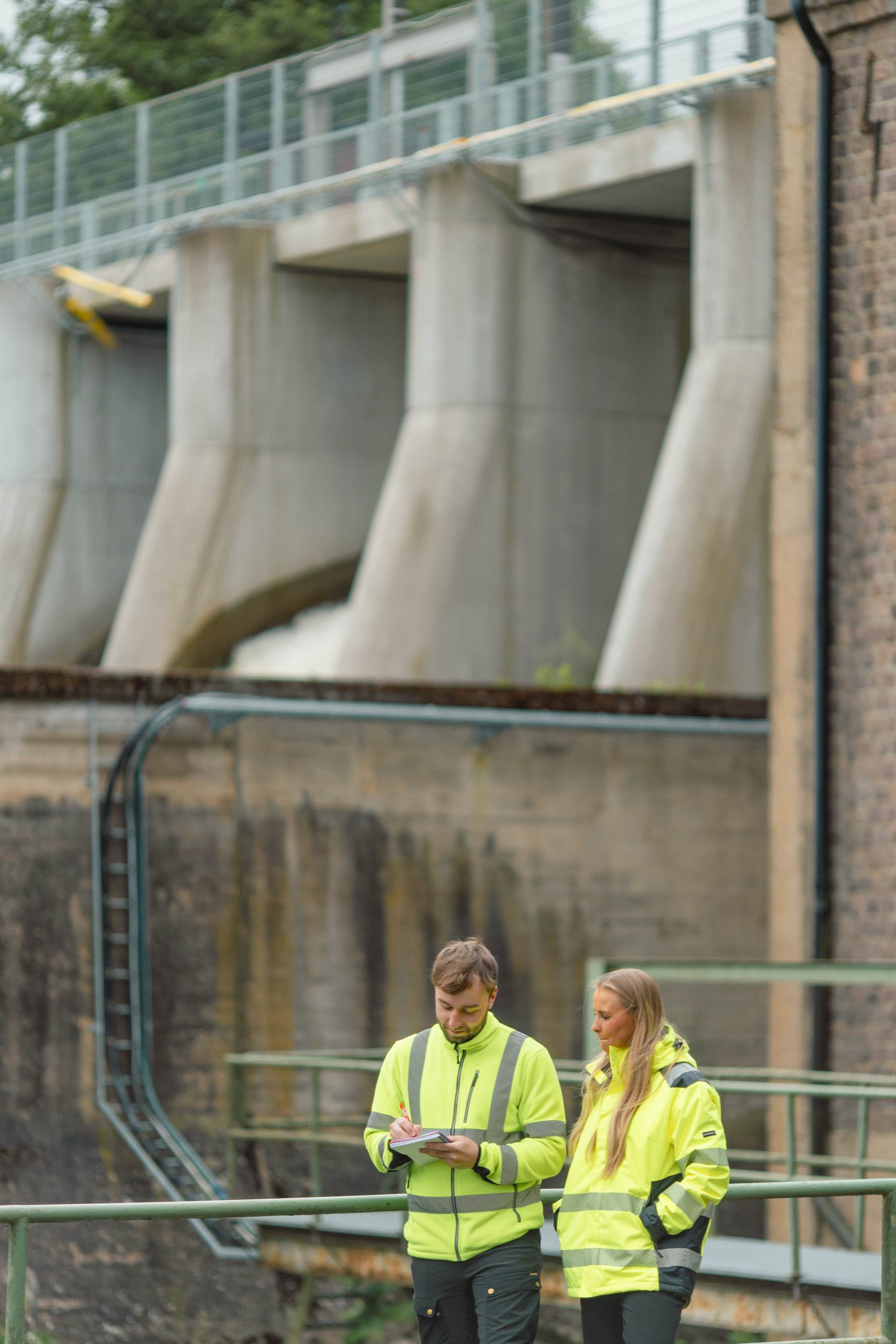 Two SeaPattern staff at a hydropower plant's dam gates